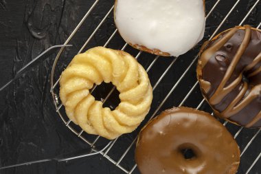 Bir ürün yelpazesine bir tel raf sırlı ve çikolata kaplı çörek otur.