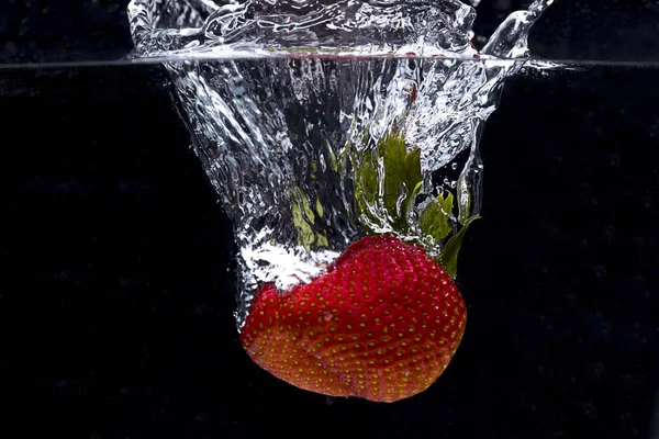 Grande fragola caduta in acqua . — Foto Stock