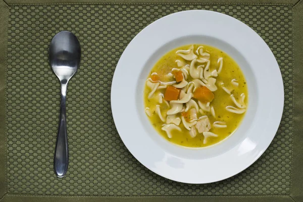 Sopa de fideos de pollo y una cuchara . — Foto de Stock