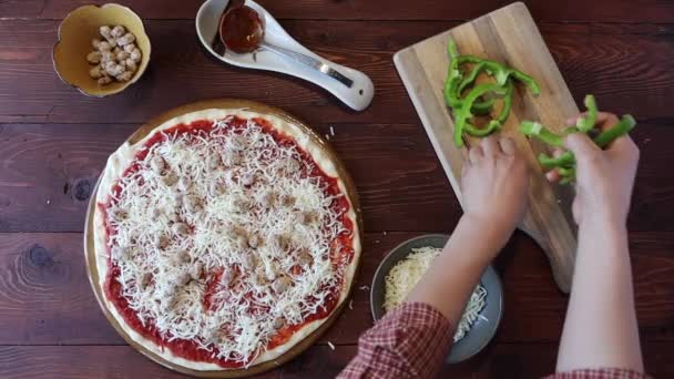 Colocando pimentas verdes em uma pizza . — Vídeo de Stock
