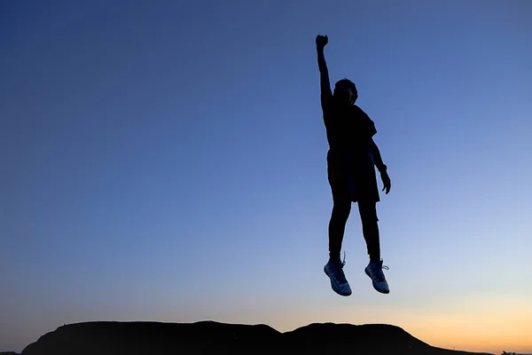 Conceptual photo of boy at sunset leaping. — Stock Photo, Image