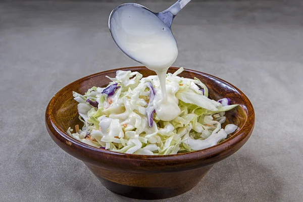 Pouring dressing over coleslaw. — Stock Photo, Image