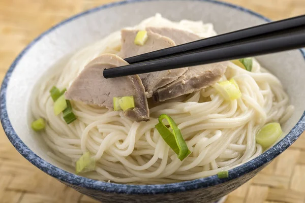 Grabbing pork slice from top of noodles. — Stock Photo, Image