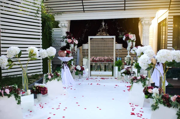 結婚式のフォト セッション装飾屋外の壁 赤花から装飾 オルテンシア ラナンキュラス 床の上の花びら — ストック写真