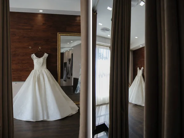白色婚纱礼服与珠子和花边在木墙挂在镜子上的看法 — 图库照片