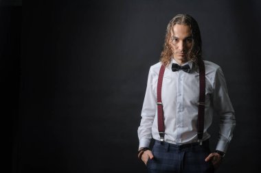 Beyaz gömlek kravat ve makara, genç yakışıklı çocuk elleri ceplerinde, siyah arka plan ile