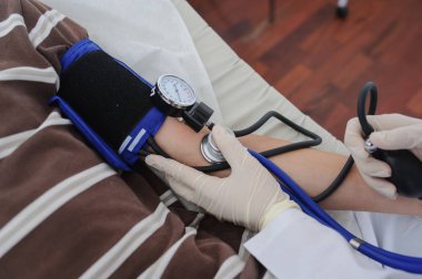 Bayan Doktor hasta elini görünümü Kapat, stetoskop ile danışmanlık