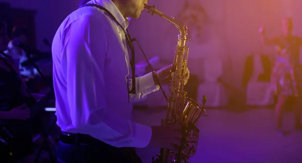 萨克斯管吹奏者普兰在晚会上 五彩缤纷的灯光 — 图库照片