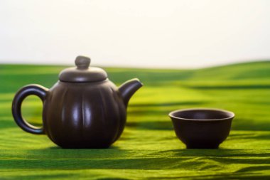 Bir bardak ve bir su ısıtıcısı seramik yeşil arka planda, görünümü Kapat