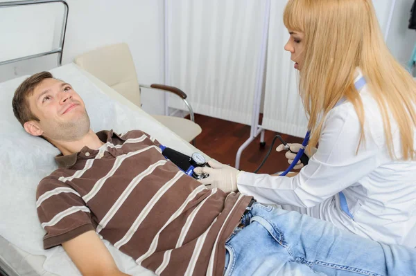 The lady doctor is consulting the patient with stethoscope at his hand, close view