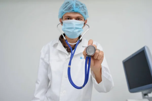 El médico con la máscara y el estetoscopio en la mano — Foto de Stock