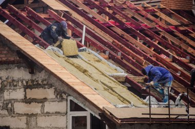 İnşaatta yüksek bir binanın çatısında.