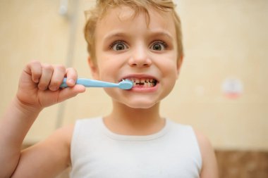 Sarışın bir çocuğun banyoda dişlerini temizlerken fotoğrafını çek.