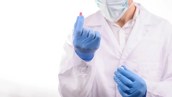 Médico Con Máscara Uniforme Blanco Mirando Una Cápsula Roja Que — Foto de Stock