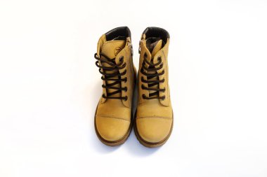 Beyaz arka planda sarı deri çocuk ayakkabısı.