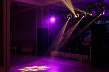 Karanlıkta parti sahnesi, ışık ve insan siluetleriyle