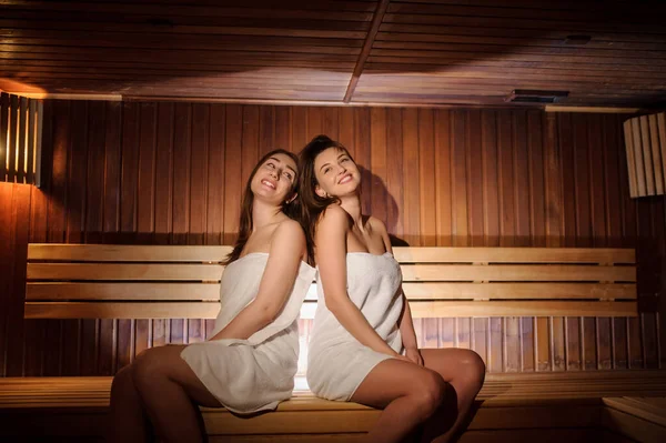 Close Foto Duas Mulheres Bonitas Vestindo Toalhas Brancas Uma Sauna — Fotografia de Stock