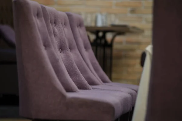 lateral view of three purple chairs in a restaurant