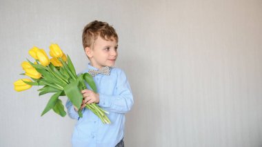 Elinde sarı laleler olan küçük bir çocuğun fotoğrafını çek.