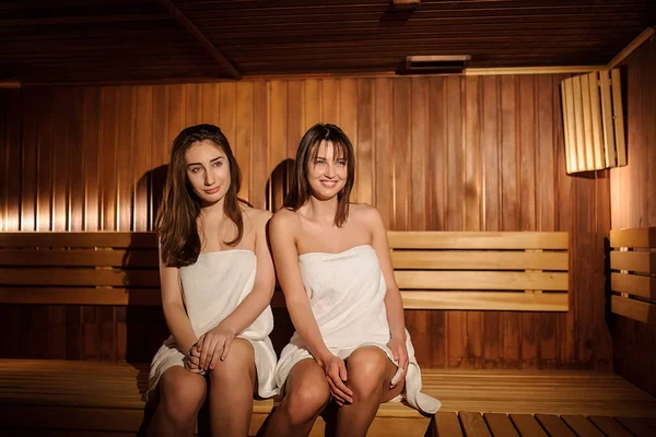 Close Foto Duas Mulheres Bonitas Vestindo Toalhas Brancas Uma Sauna — Fotografia de Stock