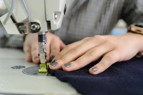 工場でミシンで縫う若い女性の手の写真を閉じて — ストック写真