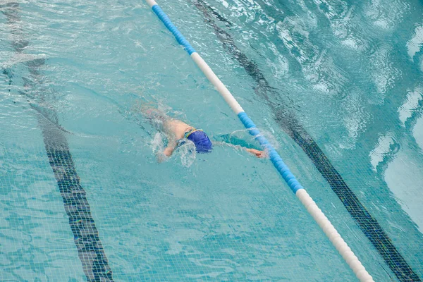 在游泳池里游泳仰泳的7岁男孩的头像 — 图库照片