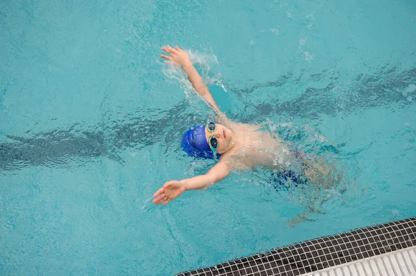 在游泳池里游泳仰泳的7岁男孩的头像 — 图库照片