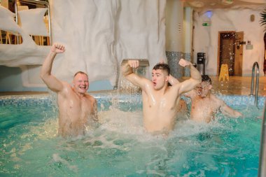 Kaplıca merkezinde yüzme havuzunda rahatlayan dört adamın fotoğrafını çek.