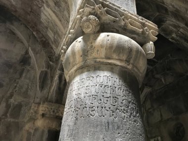 Sanahin Manastırı Ermenistan'da, karmaşık antik süs eşyaları ve Ermeni alfabesinin harfleri ile sütun. 
