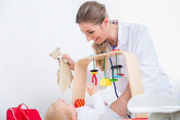 Dedicated pediatrician playing with a healthy and active baby