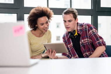 Tablet Pc ofiste bir video izlerken iki genç işçilerin