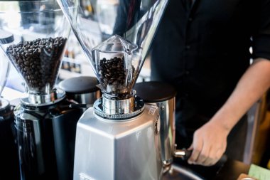 Genç barista kahve taze öğütülmüş kavrulmuş fasulye hazırlama 