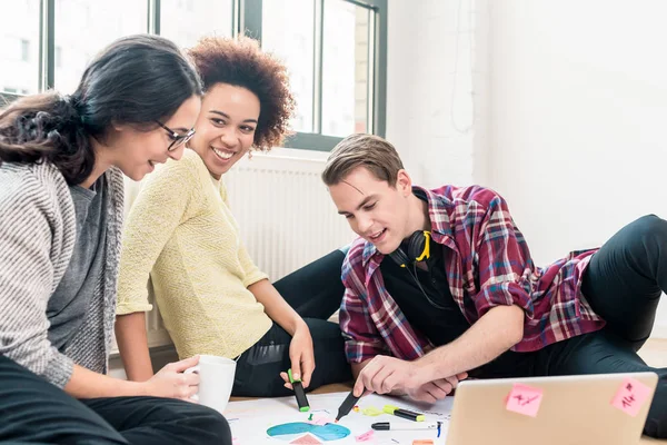 Tres jóvenes empleados creativos trabajando juntos en un proyecto — Foto de Stock