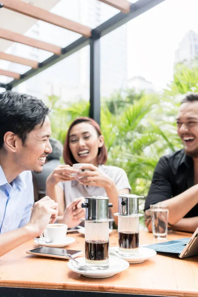 ベトナム コーヒーは、3 人の友人を屋外のテーブルで提供しています — ストック写真