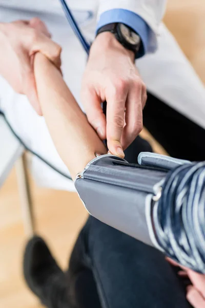 Рука врача, измеряющего кровяное давление пациента — стоковое фото