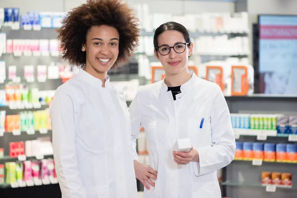 Ritratto di due farmacisti che sorridono con sicurezza al lavoro — Foto Stock