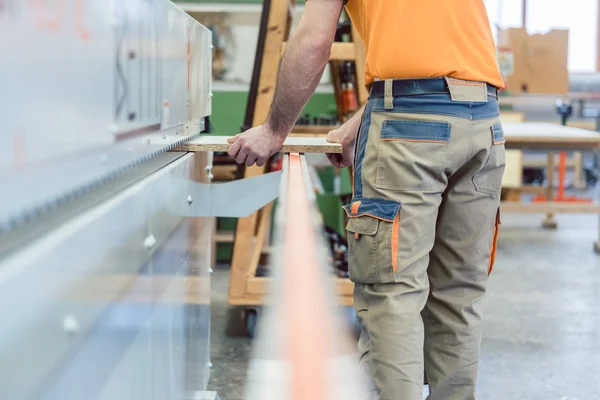 Carpenter working in furniture factory on machine — Stock Photo, Image