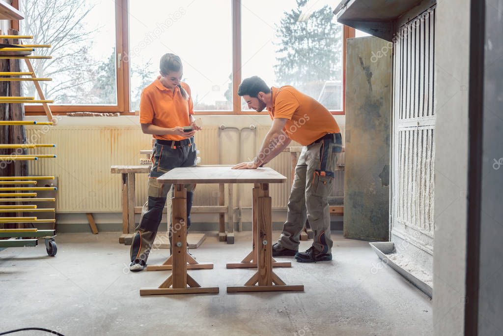 Team oft wo carpenters working on a table