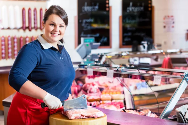 Metzgerfrau hackt Fleisch auf einem Klotz — Stockfoto