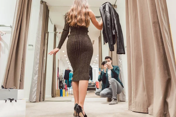 男人用她的新衣服在时装店拍他的妻子的照片 — 图库照片