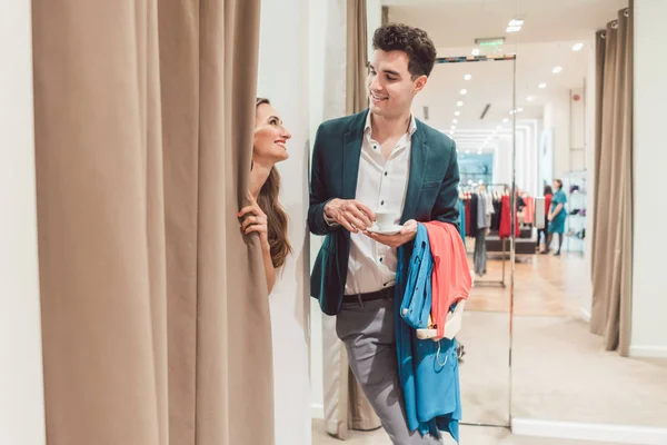 Homem na loja de moda à espera de sua mulher para aparecer a partir do provador — Fotografia de Stock