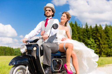 Gelin çift motorlu scooter elbisesi ve takım elbise giyen sürüş