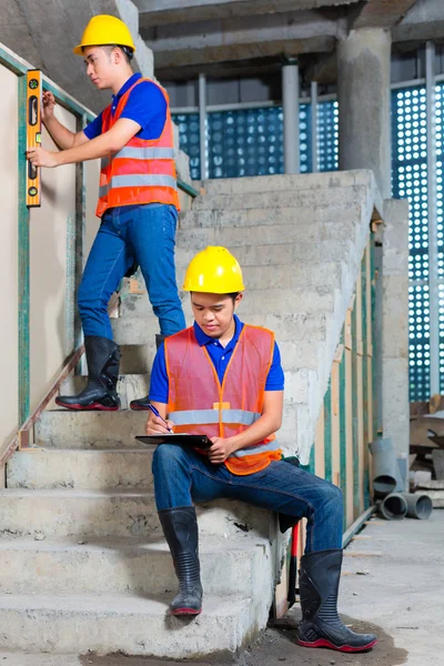 Trabajadores asiáticos en obras de construcción o paredes — Foto de Stock