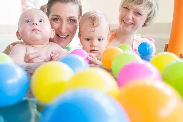 Las mamás y los bebés se divierten en el curso de natación infantil — Foto de Stock