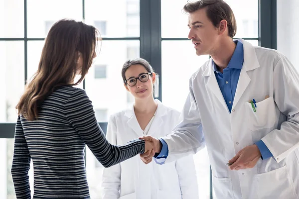Betrouwbare arts en vrouwelijke patiënt schudden handen voordat overleg — Stockfoto