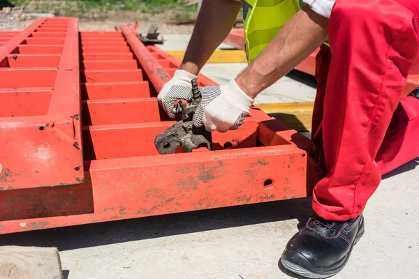 Travailleur installant un cadre métallique pendant le travail — Photo