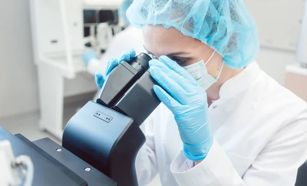 Mulher cientista trabalhando no microscópio — Fotografia de Stock