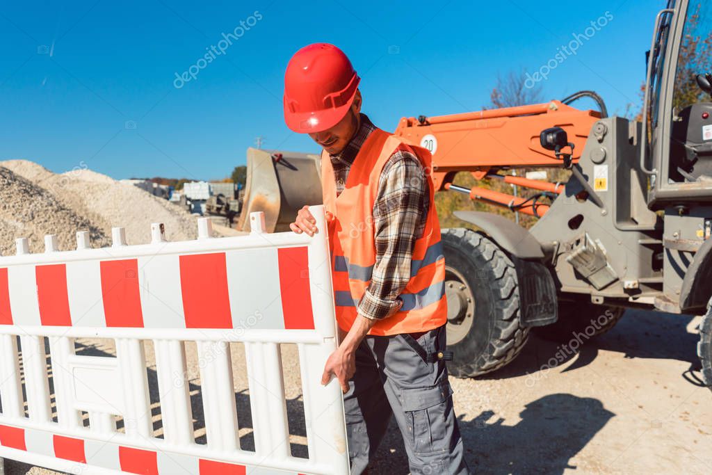 Worker setting up earthworks construction site