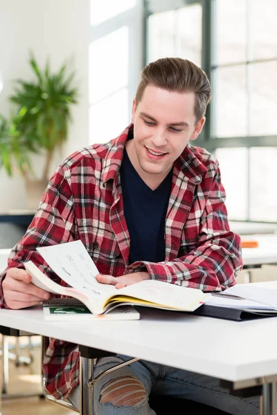 Portret van een jonge student glimlachen terwijl het onderzoeken van informatie — Stockfoto