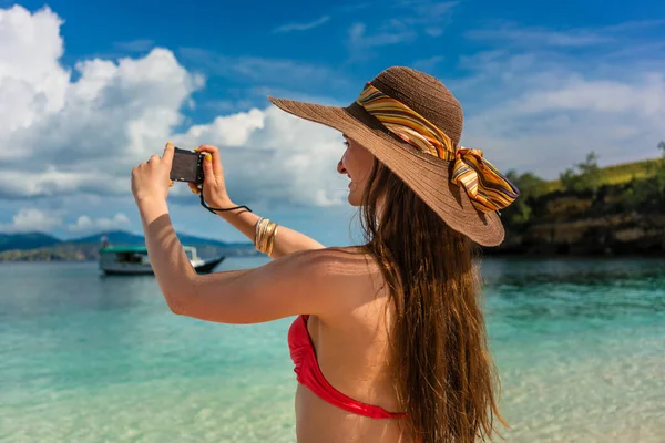 Jeune femme prenant des photos dans une journée ensoleillée pendant les vacances d'été — Photo